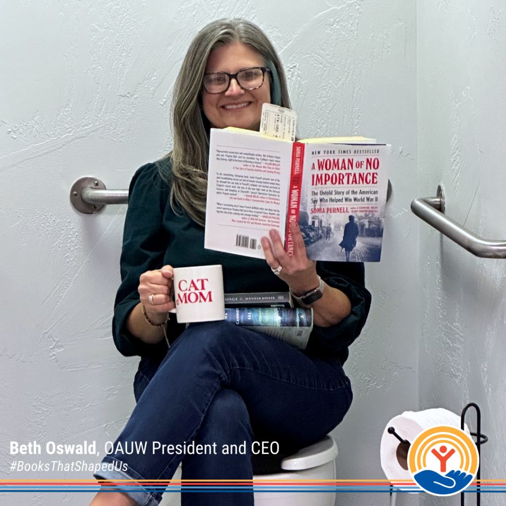 Beth Oswald, CEO of Oshkosh Area United Way, holding a book and sharing how A Tree Grows in Brooklyn sparked her passion for history and reading.